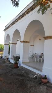 un edificio blanco con arcos y una mesa en Dimora di nonna Nina, en Galatone