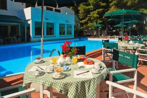 a table with food and flowers on it next to a pool at Hotel Kyrie Isole Tremiti in San Domino