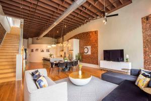 ノックスビルにあるLargest Rooftop w Firepit - Vaulted LUXE Penthouseのソファのあるリビングルームとダイニングルーム