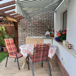 a patio with a table and chairs and a kitchen at Rózsa Vendégház in Visegrád