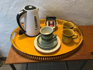 a tray with a tea kettle and cups on a table at Doubleroom in basement w own bathroom in Rörum, Österlen in Simrishamn