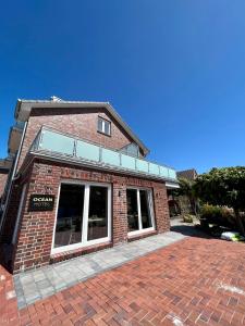 a red brick building with windows on a brick sidewalk at Hotel Ocean in Norden