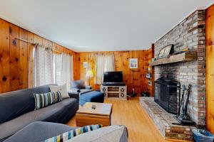 sala de estar con sofá y chimenea en Island Forest Retreat, en West Tisbury