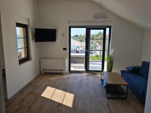 沃希Appartments Akrapovic的客厅里有一张蓝色的沙发和一张桌子