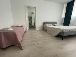 2 camas num quarto branco com pisos em madeira em I Cavour 108 em Porto SantʼElpidio
