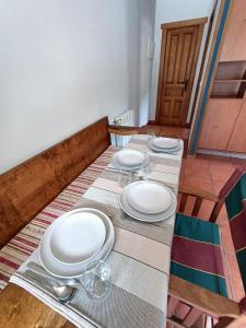 una mesa con platos blancos y vasos. en La Fragua de La Vega Estudios, en La Vega