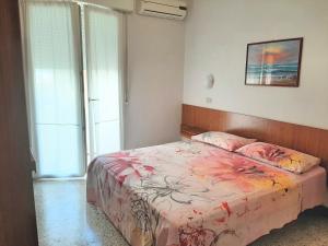 een slaapkamer met een bed met een roze dekbed bij Hotel Amalfi in Rimini