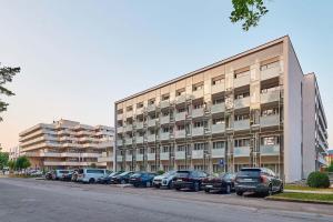 a large building with cars parked in a parking lot at apartmán MONYA in Turčianske Teplice