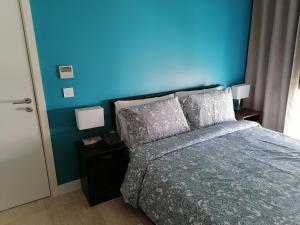 Blue Diamond Ayla - Restricted to Family stays في العقبة: غرفة نوم بحائط ازرق وسرير مع مخدات