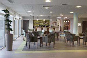 a restaurant with tables and chairs and a counter at Domitys La Fleur de Lin in Landerneau +11 photos