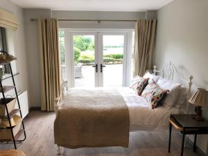 a bedroom with a bed and a sliding glass door at Ardhowen Bay lakefront holiday accommodation in Enniskillen