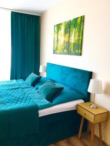 - une chambre avec un lit bleu et une tête de lit bleue dans l'établissement apartmán MONYA, à Turčianske Teplice