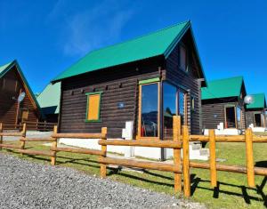 une petite cabine avec un toit vert et une clôture dans l'établissement Black Pine, à Žabljak