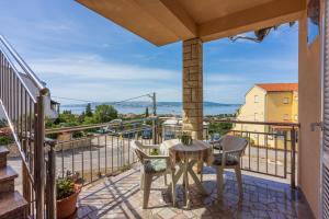 a patio with a table and chairs on a balcony at Apartmani Jarić in Novi Vinodolski