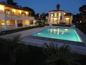 - une piscine en face d'une maison la nuit dans l'établissement Villa Playa del Sol - B2, à Saint-Tropez