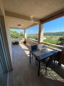 a patio with a table and chairs on a balcony at Apartman Ana in Rab