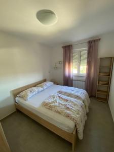 a bedroom with a large bed in a room at Apartman Ana in Rab