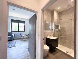 a bathroom with a shower and a toilet and a sink at Omega Inn in Milton Keynes