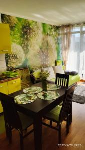 a dining room table with plates and chairs in a room at Apartament Limonka in Kołobrzeg