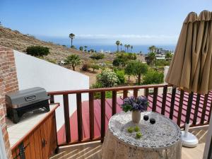 a balcony with a table with flowers and a grill at BUNGALOW private pool bbq air conditioning stunning ocean view in Adeje