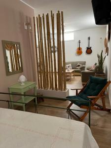 ein Wohnzimmer mit einem grünen Stuhl und einer Couch in der Unterkunft Tavernetta Open space in Specchia