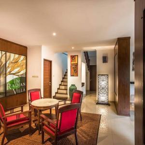een woonkamer met een tafel, stoelen en een trap bij The Radian Villa Ubud in Ubud