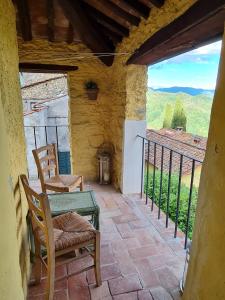 a patio with two chairs and a table and a view at Torre del Duca in Bagni di Lucca