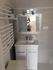 a bathroom with a sink and a mirror at Apartament Jastrzębia Góra 12 B in Władysławowo