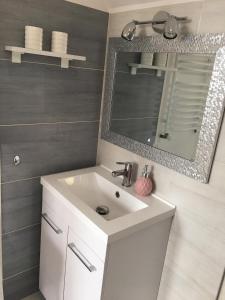 a bathroom with a white sink and a mirror at Apartament Jastrzębia Góra 12 B in Władysławowo