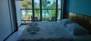 a bedroom with a bed with a view of the ocean at Araçá Praia Flat - Ponta Negra in Natal
