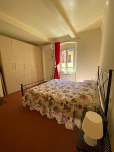 a bedroom with a bed with a floral bedspread at L'orologio matto in Marina di Carrara
