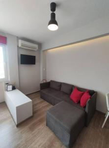 soggiorno con divano grigio e cuscini rossi di Antelope Studio 1 a Salonicco