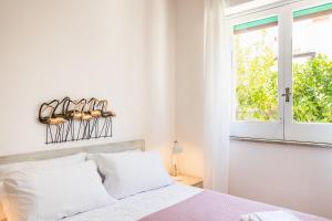 Habitación blanca con cama y ventana en Ville Colonia Marina, en Marina di Noto