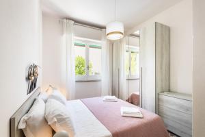 Dormitorio blanco con cama con manta rosa en Ville Colonia Marina, en Marina di Noto