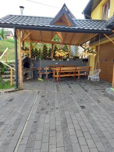 a pavilion with a picnic table and a fireplace at Apartamenty Pod Skałką in Szaflary