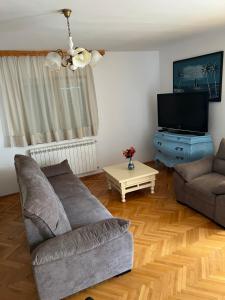 a living room with a couch and a tv at Zajim Apartment in Umag