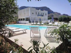 a swimming pool with chairs and a house at Inkantu B&B in Terrasini
