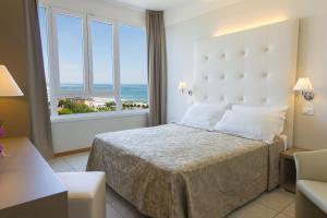a hotel room with a bed and a large window at Hotel Cristallo in Riccione +51 photos
