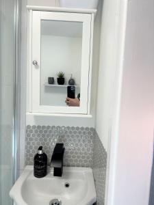 a bathroom with a sink and a mirror above it at Cosy retreat in beautiful Cornwall in Helston