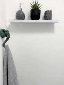 a shelf on a wall with a towel and plants at Cosy retreat in beautiful Cornwall in Helston