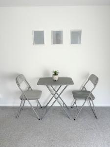 two chairs and a table with a potted plant on it at Cosy retreat in beautiful Cornwall in Helston