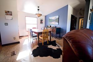 een woonkamer met een tafel en stoelen en een bank bij Sunny Southwest Cottage in Mancos