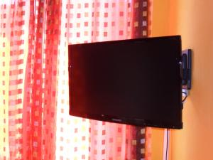 einem an einem Vorhang befestigten Flachbild-TV in der Unterkunft Sa Domo de Minnanna in Castelsardo