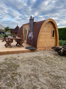 een houten hut met een parasol op een terras bij Le charmant Pod du Parolais in Beauvoisin