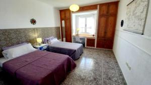 a hotel room with two beds and a desk at Casa Natura Ainhoa in La Oliva