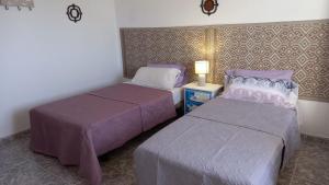 a bedroom with two beds and a lamp on a table at Casa Natura Ainhoa in La Oliva