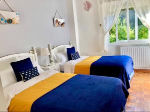 a bedroom with two beds with blue and yellow at Apartamento con vistas al mar en Primera Línea. in Muros