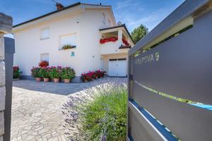 a white house with potted plants in front of it at Apartments Hortensia in Pula