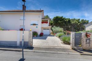 a white house with a fence and a driveway at Apartments Hortensia in Pula