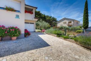 a driveway leading to a house with flowers at Apartments Hortensia in Pula